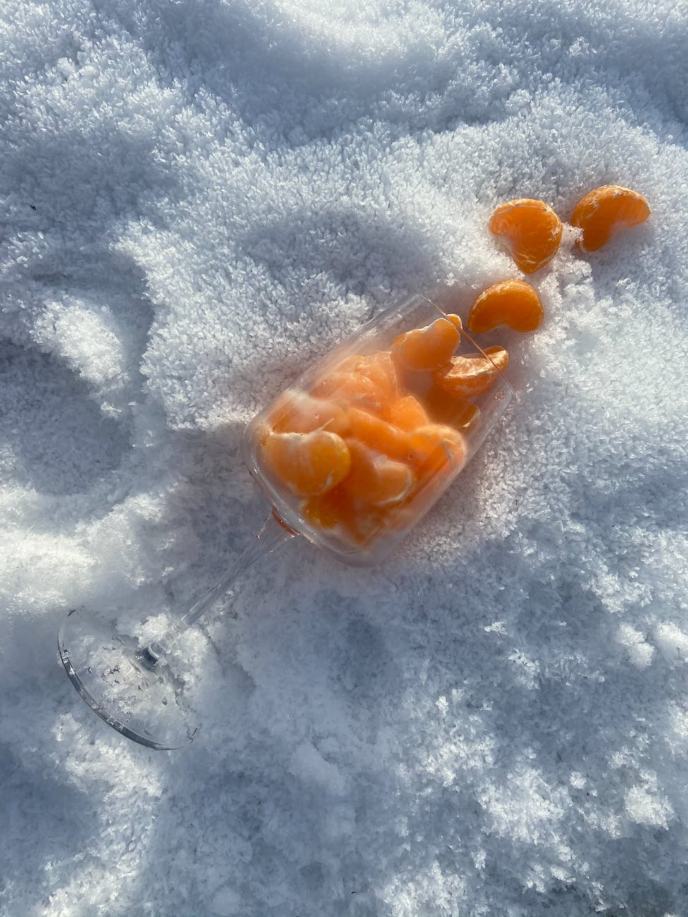 glass of tangerines on snow tips to help with seasonal depression months
