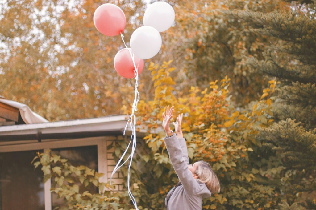 woman in gray jacket released balloons in the air, grieving the old you, grieve the old you, grieve the life you thought you'd have